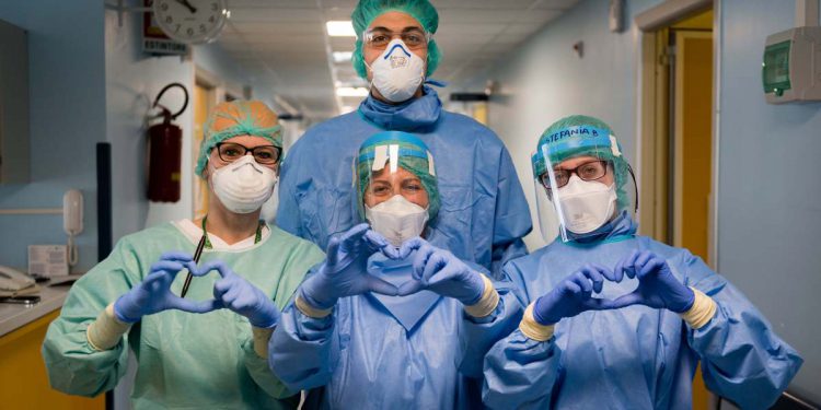 CREMONA, ITALY - MARCH 29: (EDITORIAL USE ONLY) Nurses making the hearth sign at Cremona Hospital on March 29, 2020 in Cremona, Italy. The Italian government continues to enforce the nationwide lockdown measures to control the spread of coronavirus / COVID-19. (Photo by Marco Mantovani/Getty Images)