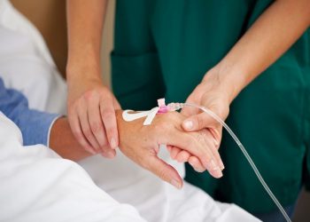 Female doctor checking patients pulse in hospital