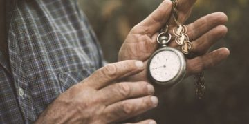 Hands holding a vintage pocket watch