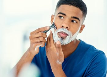 Shot of handsome young man beginning to shave his face