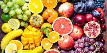 A colourful spectrum of fruit: oranges, lemons, limes, mandarins, grapes, plums, grapefruit, pomegranate, persimmons, bananas, cherries, apples, mangoes, blackberries and blueberries.