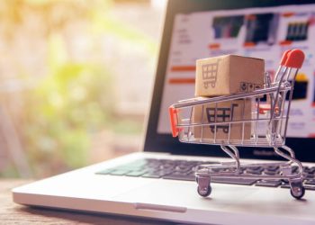 Shopping online concept - Parcel or Paper cartons with a shopping cart logo in a trolley on a laptop keyboard. Shopping service on The online web. offers home delivery.