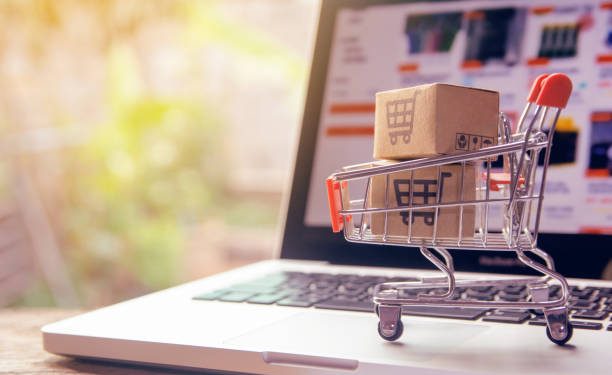 Shopping online concept - Parcel or Paper cartons with a shopping cart logo in a trolley on a laptop keyboard. Shopping service on The online web. offers home delivery.