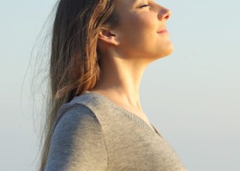 Side view portrait of a relaxed woman breathing fresh air on the beach