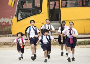 Schoolboys and schoolgirls walking of the school bus outdoor