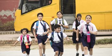 Schoolboys and schoolgirls walking of the school bus outdoor